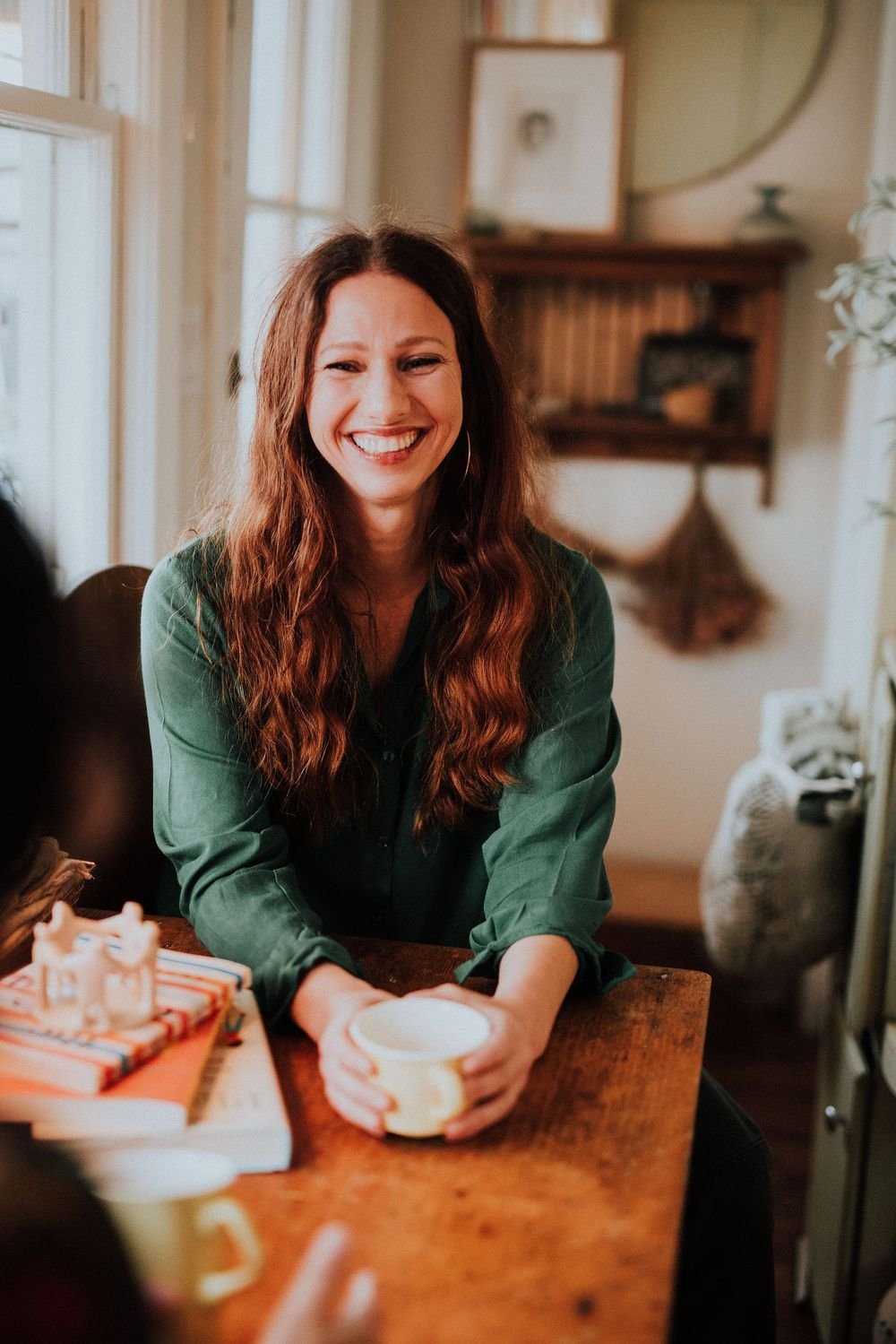 Ariana Lloyd, LCSW, LICSW, laughing at a table over coffee