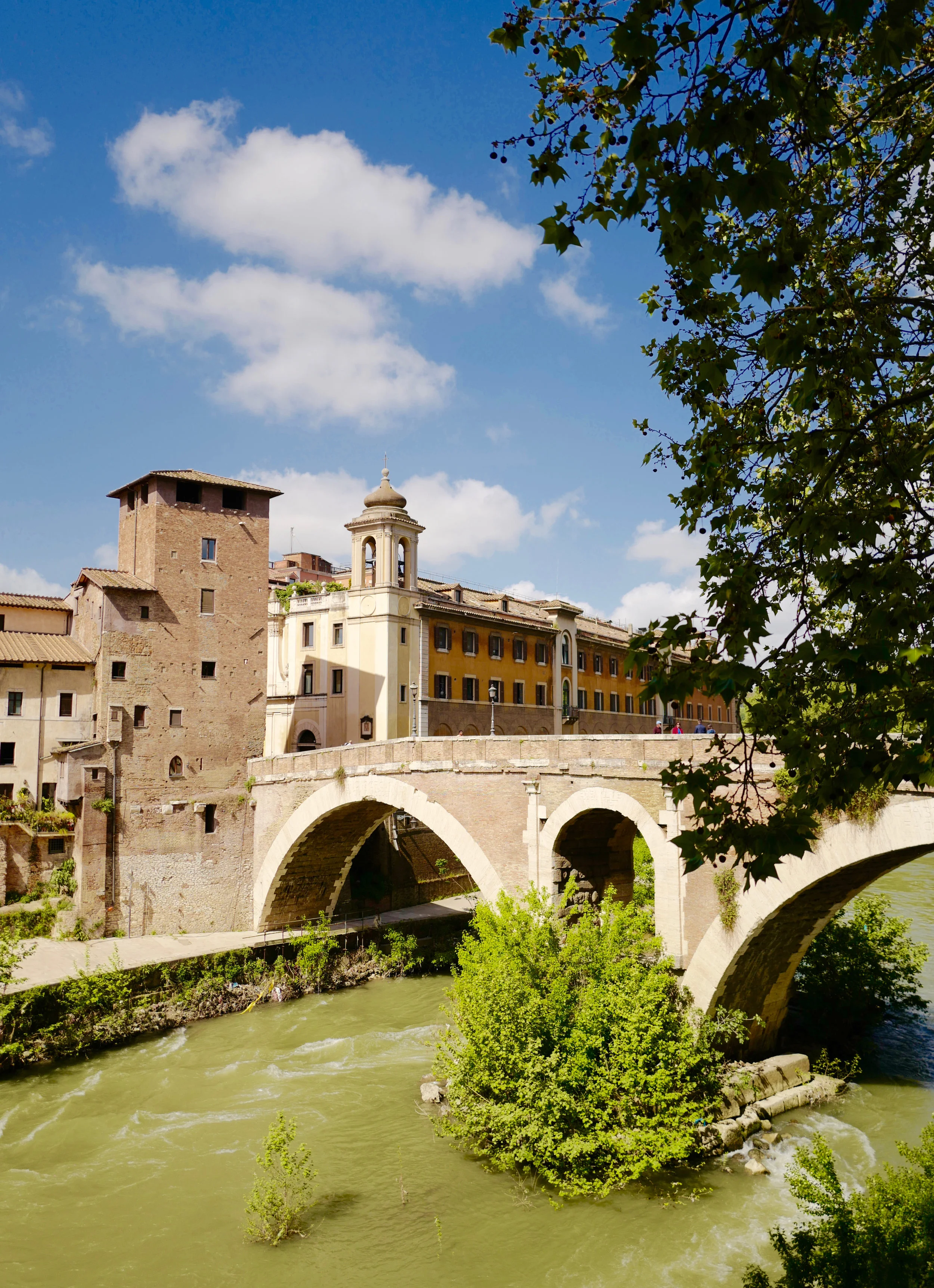 View of the Tiber River and Tiber Island. Crossing the bridge will bring you to the Trastevere neighborhood.