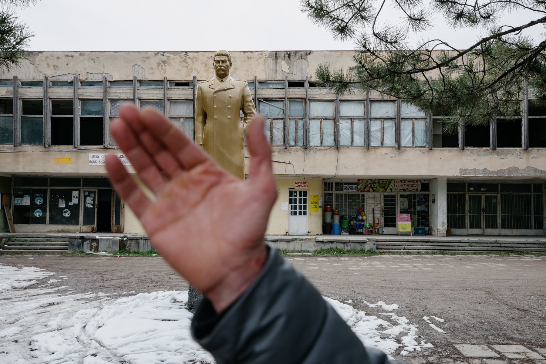  A man gestures while talking about Joseph Stalin in front of a statue of the Soviet leader in Mejvriskhevi. Born in nearby Gori, Stalin still has many supporters in his homeland. 