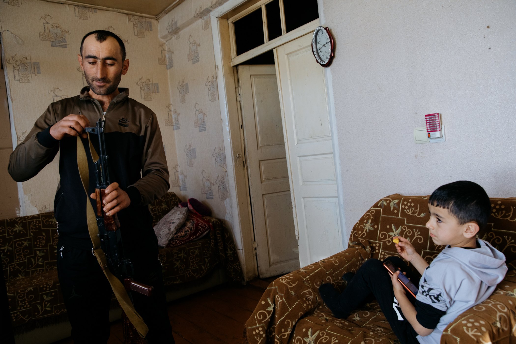  Ruben Balyan and his son Garnik in their house in Kornidzor, a village which lies directly beside the border with Azerbaijan. Ruben is a member of Ashkharazor, a territorial defence organisation, and so is allowed to own a Kalashnikov rifle. 