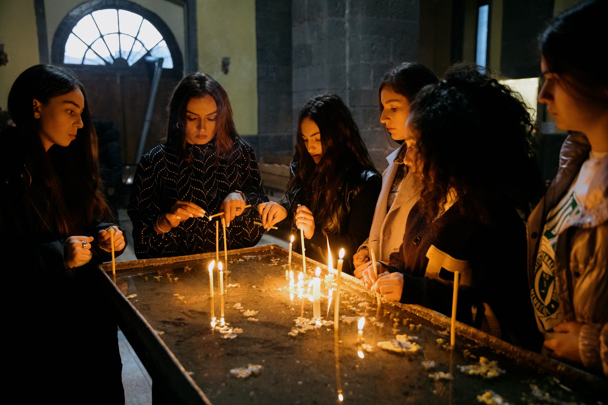  Members of the Asparez dance group from Stepanakert light candles in a church in Goris. They were taking part in a competition in Tbilisi before the blockade separated them from their families. 