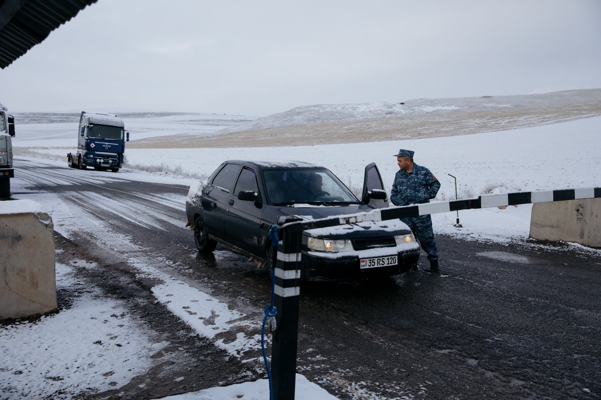  A police officer from Nagorno-Karabakh speaks to a driver at a checkpoint near the village of Tegh. The checkpoint was closed to general traffic by the Armenian authorities once the Azerbaijani blockade commenced. 