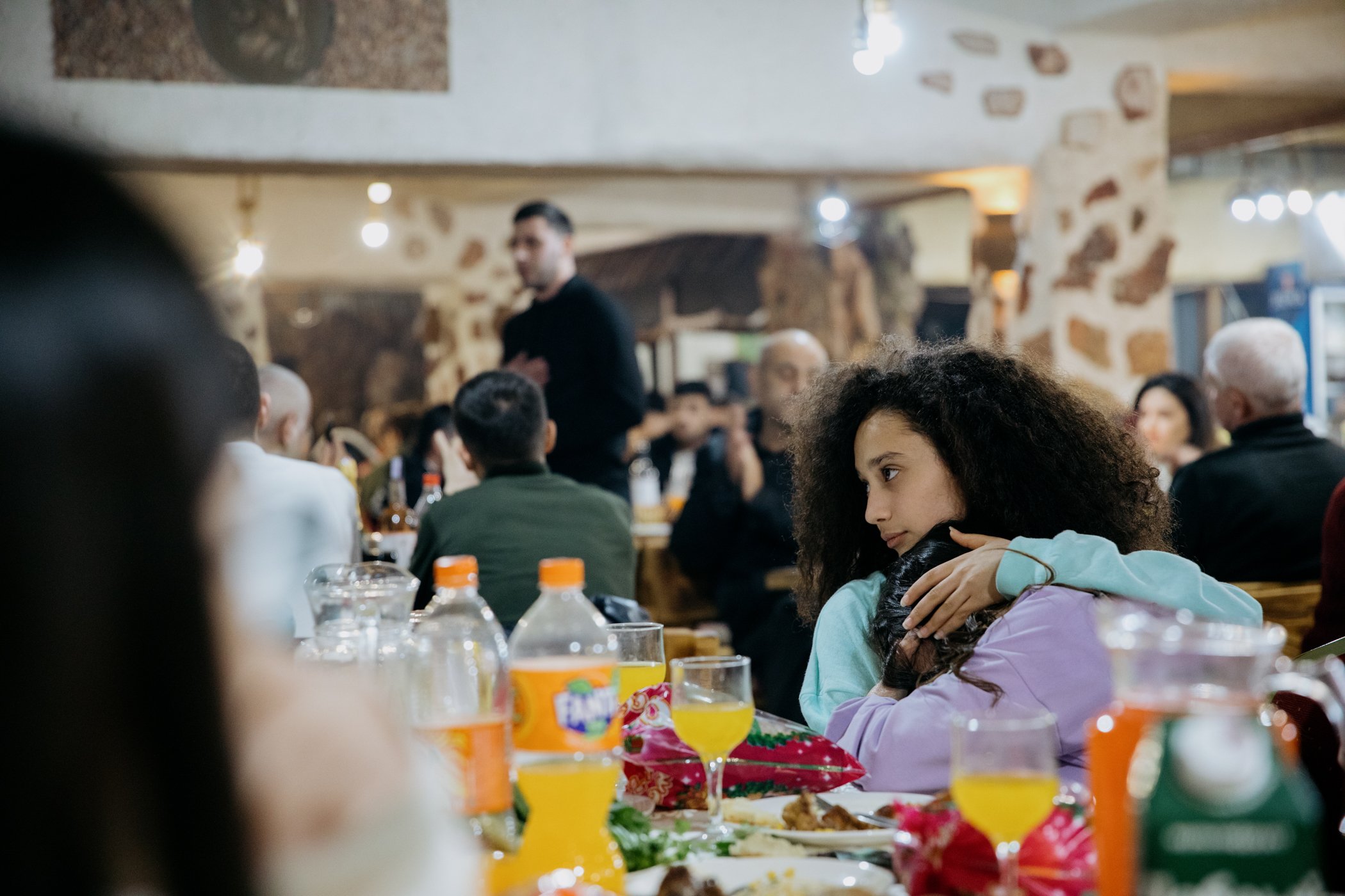  A young dancer from Stepanakert consoles her friend after a man sings an Armenian folk song during a New Year's Eve Dinner at the Hotel Goris. 