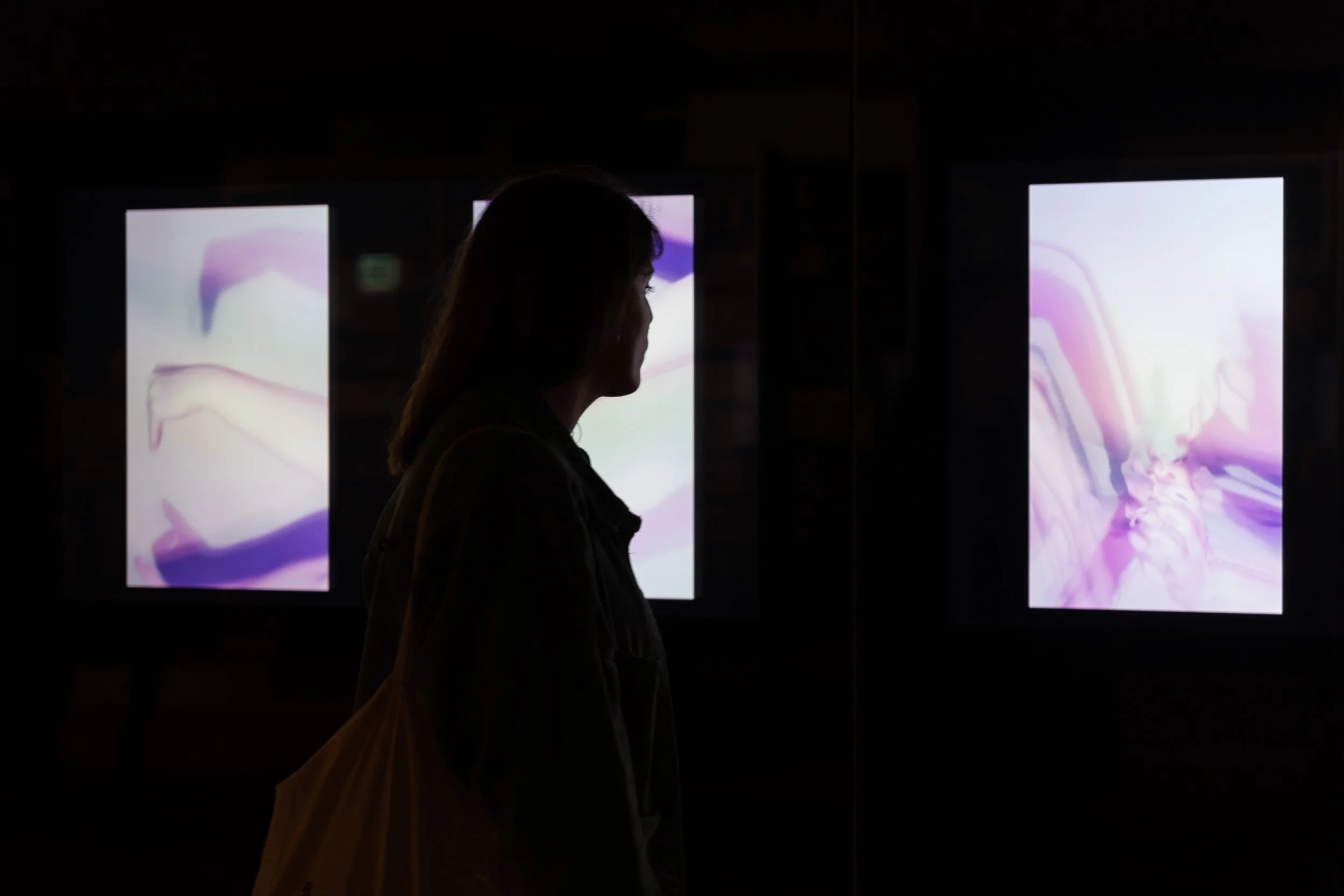 Wide view of the Finger Plays installation at Museo della Figurina, featuring immersive video projections, vertical screens and scenographic elements inspired by shadow theatre and social media culture.