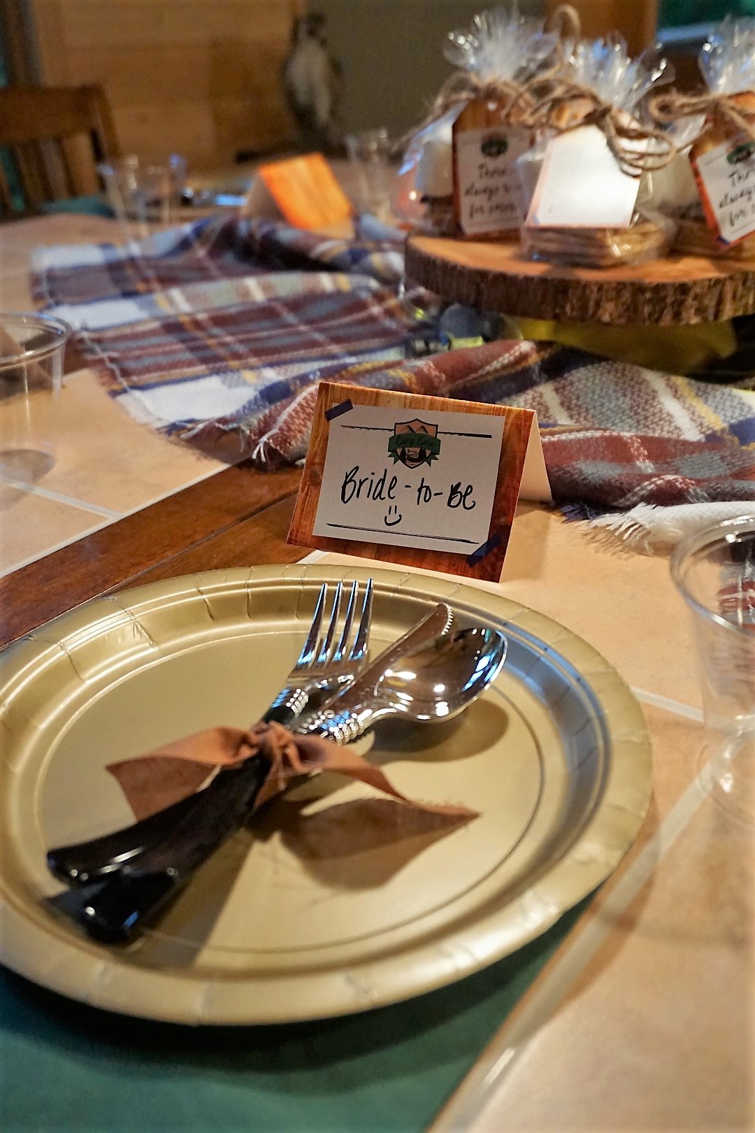  Gold plates and green napkins for camp tablescape. 