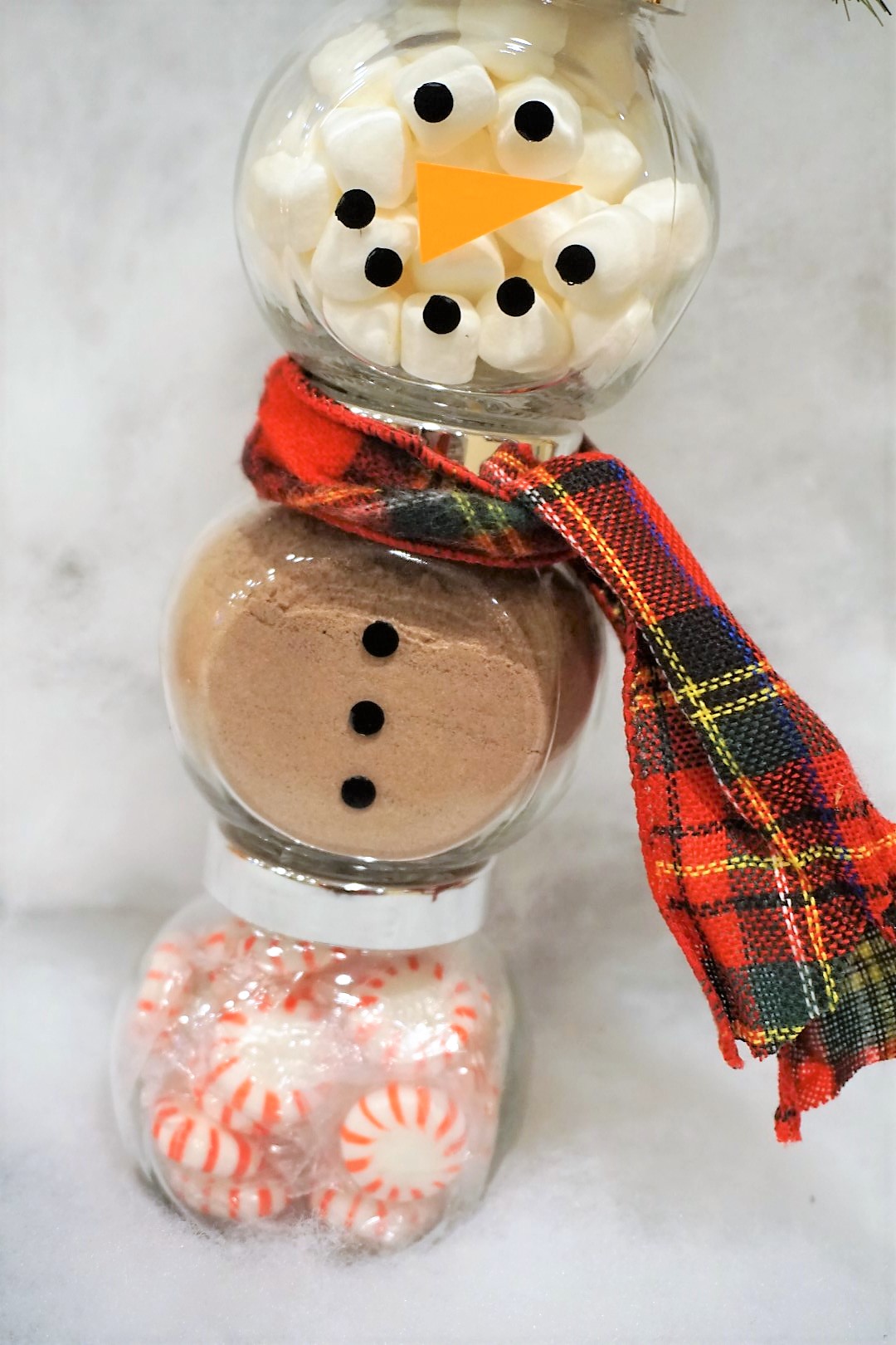  Make glass jars into a Snowman Cocoa Kit by cutting out a vinyl face and buttons by hand or using a Cricut. 
