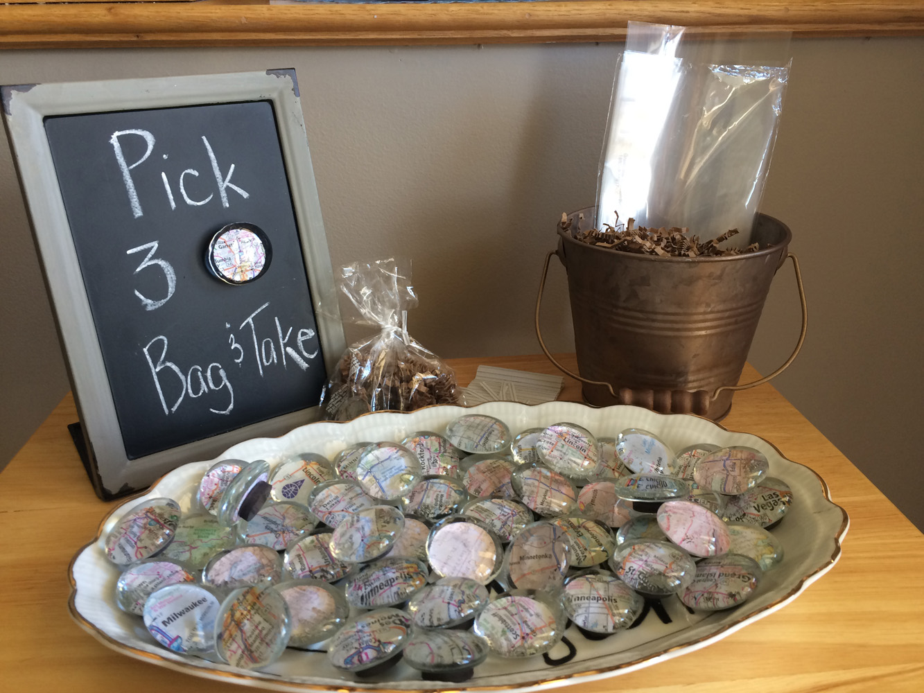  Travel themed bridal shower favor of DIY map magnets made with glass gems, map cutouts, and mod podge. 