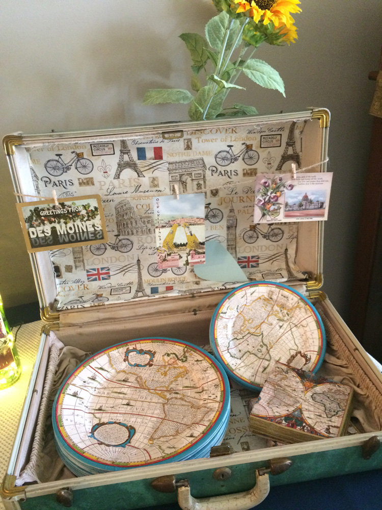  Vintage suitcase with globe plates and napkins for a travel themed bridal shower. 