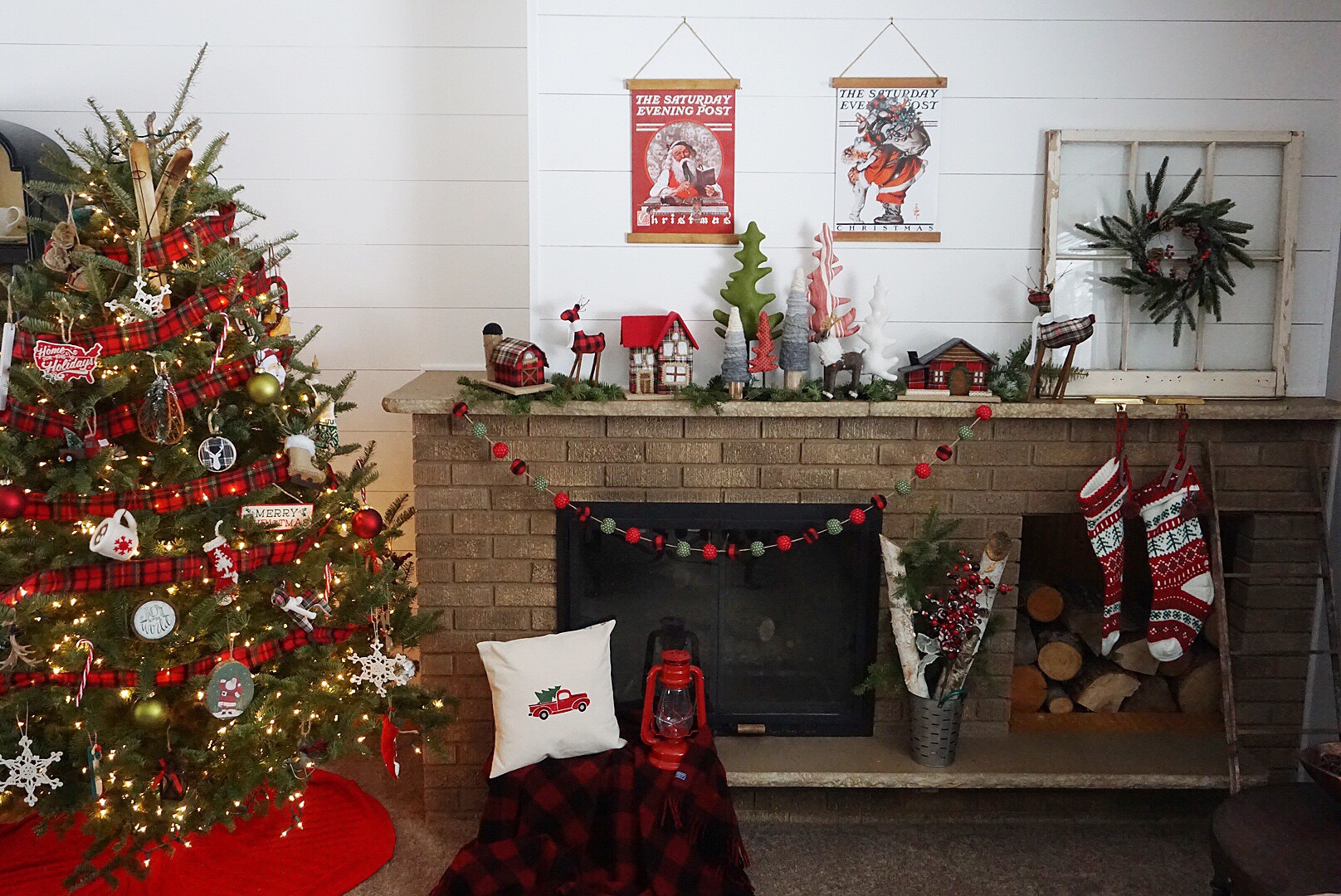  A vintage themed Christmas mantel with plaid houses, plaid pom garland, and vintage posters. 