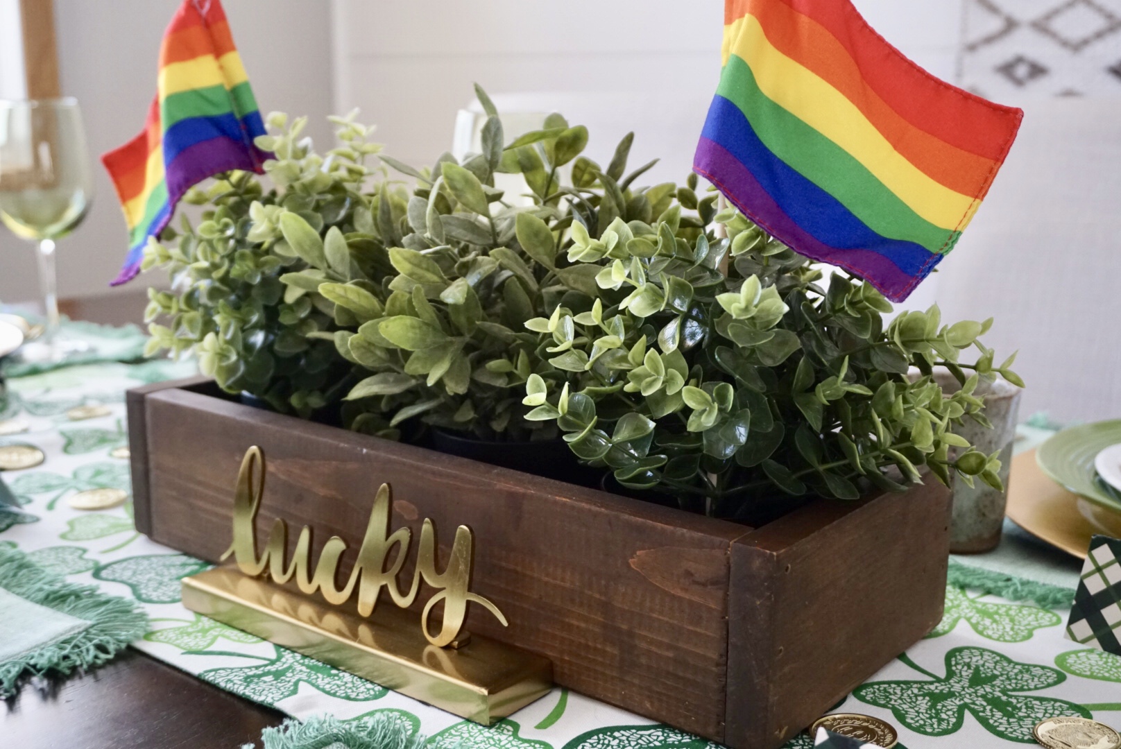  Lucky St. Patrick’s Day Centerpiece with greenery, rainbow flags, and gold signage. 