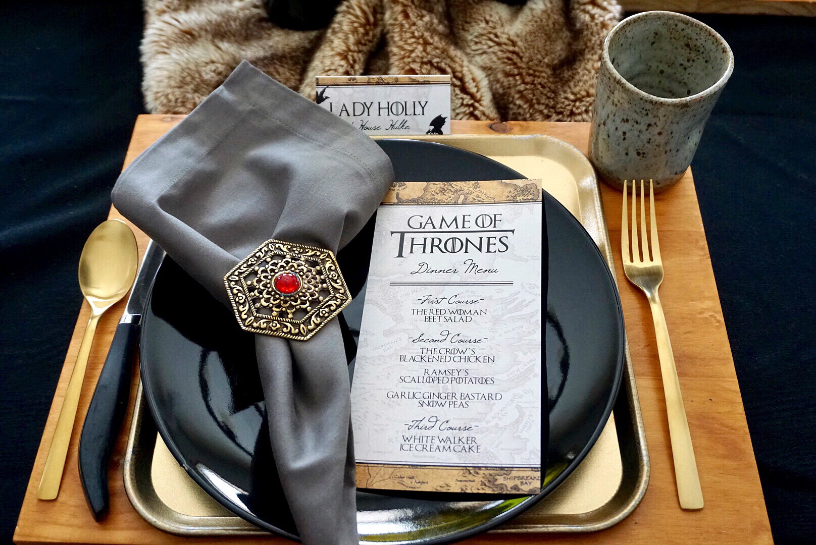  Wood chargers, gold trays, and black plates make the perfect layers for a Game of Thrones themed place setting. 