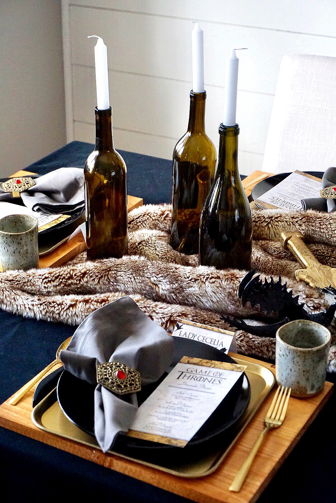  Wood chargers, gold tray, and black plates along with gold utensils make the perfect place setting for a Game of Thrones dinner party. 