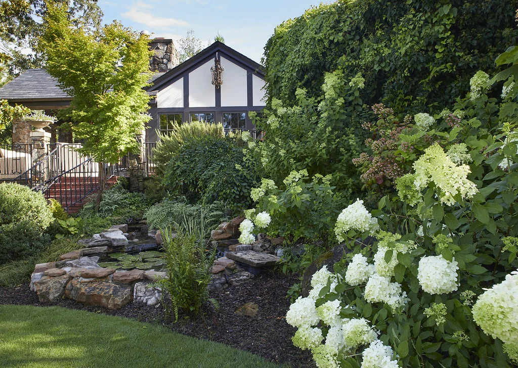 Flower bushes line the walkway to the home.