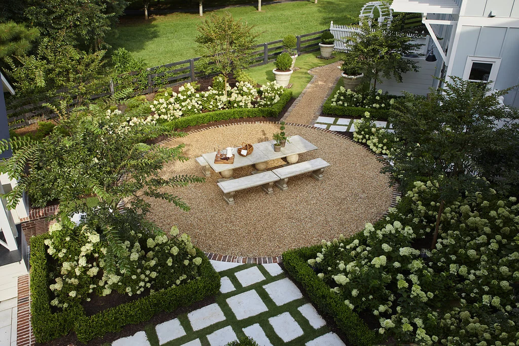 Aerial view of outdoor entertainment area surrounded by custom stonework, hydrangea bushes, and shrubbery.