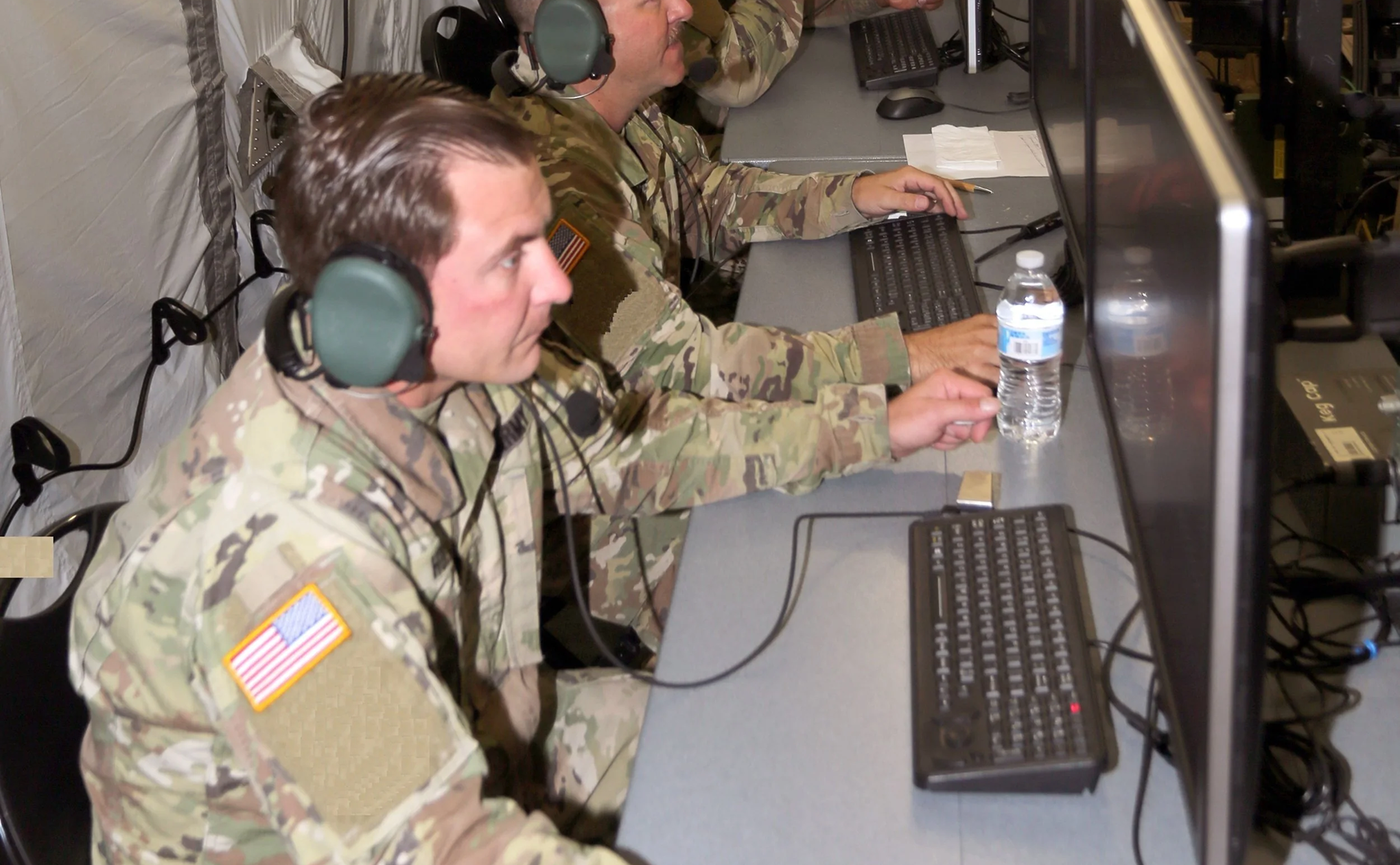 U.S. Army soldiers wearing headsets operating IBCS workstations inside a military command environment during a live intercept test at White Sands Missile Range