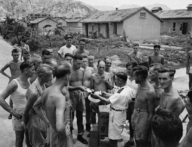 Le capitaine de corvette Fred Day du NCSM PRINCE ROBERT rencontre des prisonniers de guerre canadiens libérés au camp de Shamshuipo, Kowloon, Hong Kong, septembre 1945 Numéro d'identification: 3617924
