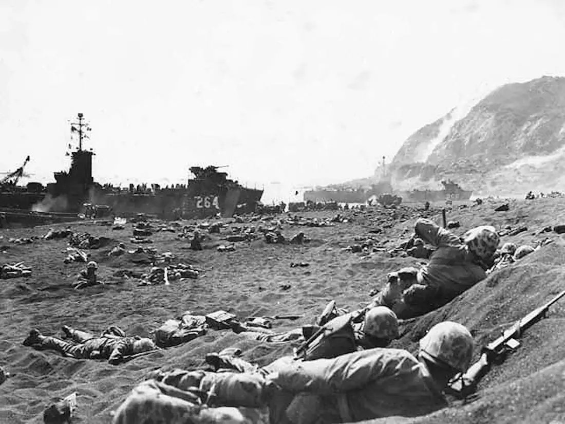 Marines burrow in the volcanic sand on the beach of Iwo Jima