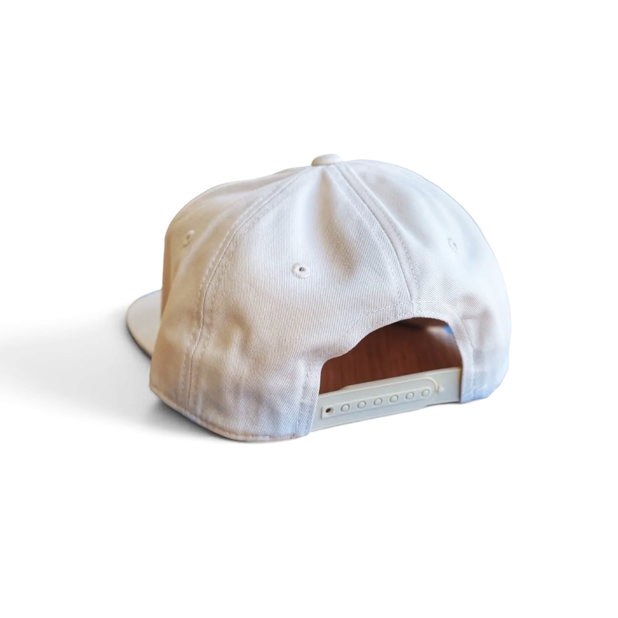 The back of an eggshell-colored Fresh off the Boat snapback cotton hat with blue embroidered patch on a clean white background.