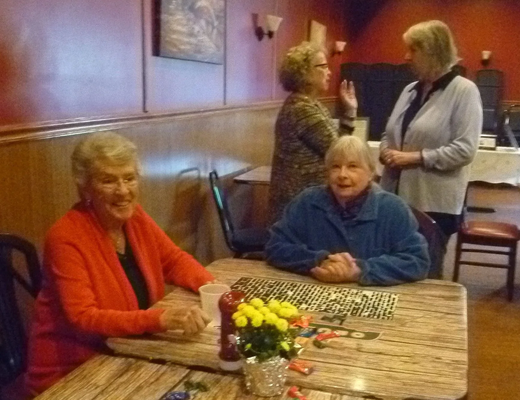  Ellie and Barb at the table, with Shar and Sherri talking in the background. 