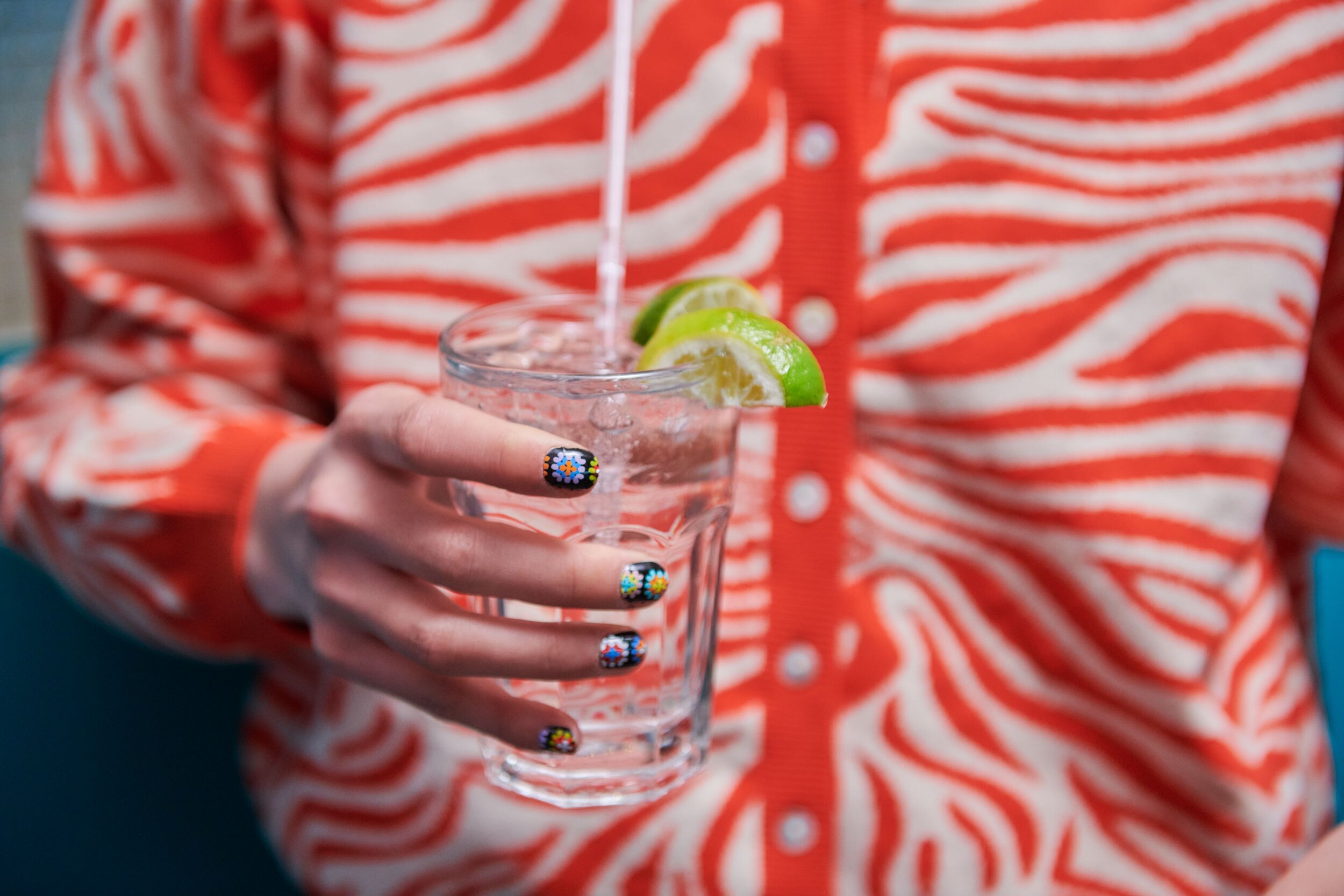 Vodka soda held by woman with decorative nails