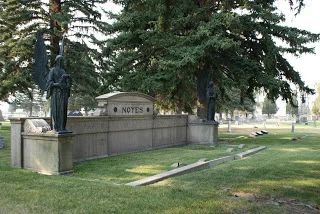 There are many different ways that family areas are denoted in a cemetery. Sometimes they are fenced. Sometimes they have monogrammed stones to show the area. Or you could create a monumental wall such as this one, adorned with two angels, to mark the family's area.