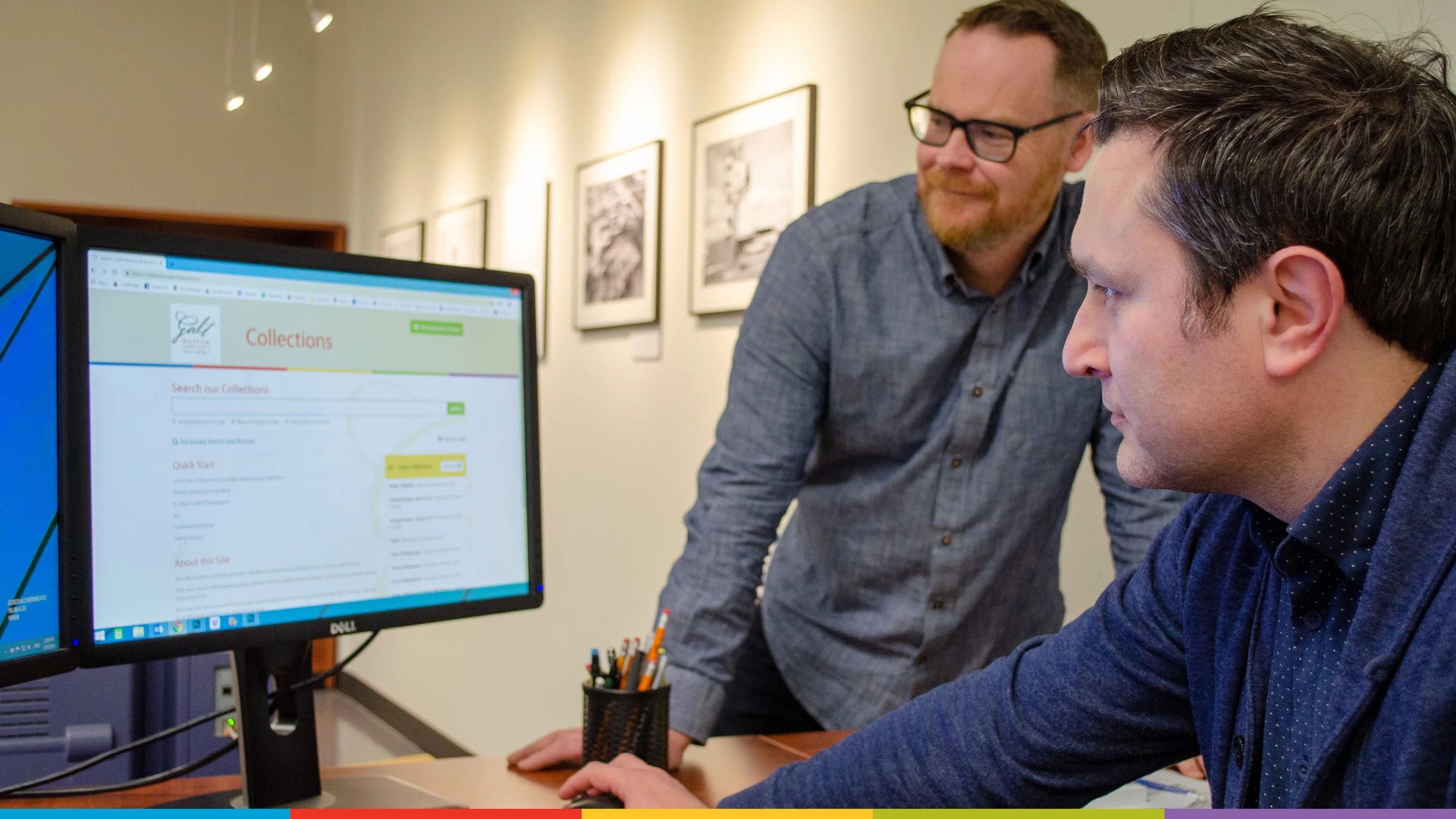 A photo of Archivist Andrew Chernevych and Collections Technician Kevin MacLean looking at the Galt’s new online database website on a computer screen.