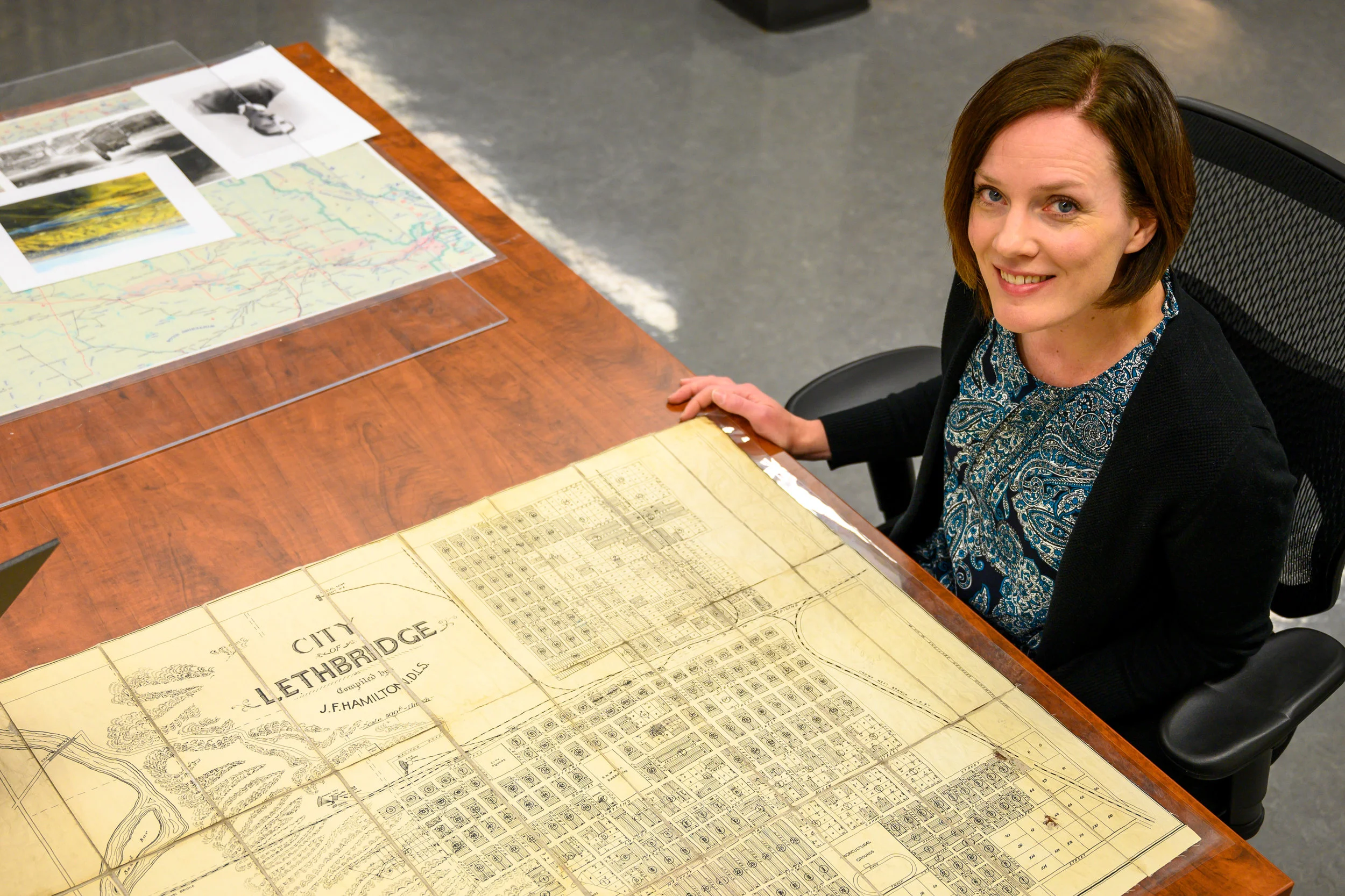 Curator Aimee Benoit with a 1909 map of Lethbridge.