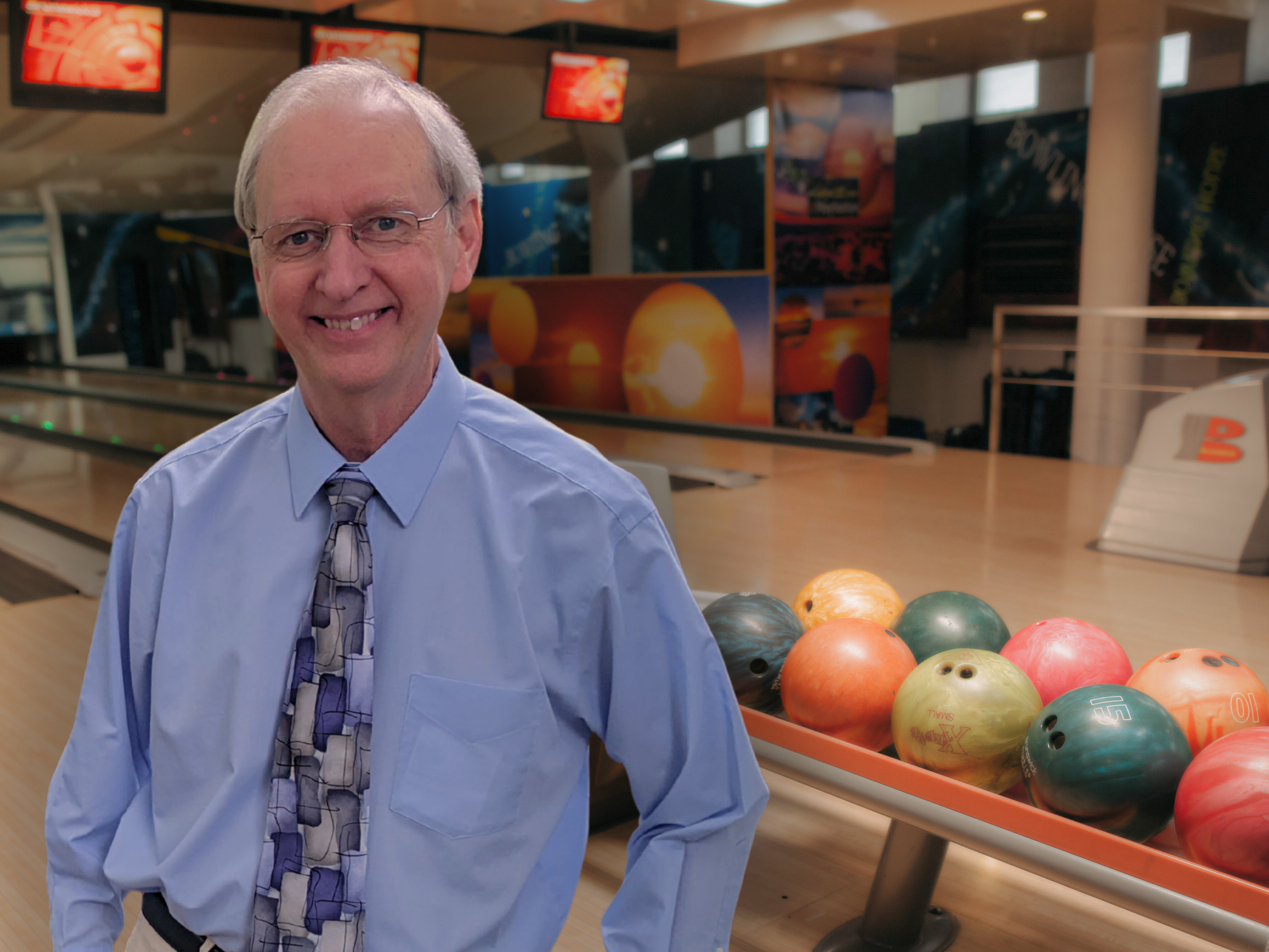 Coach Tom Reid Standing by a bowling lane.