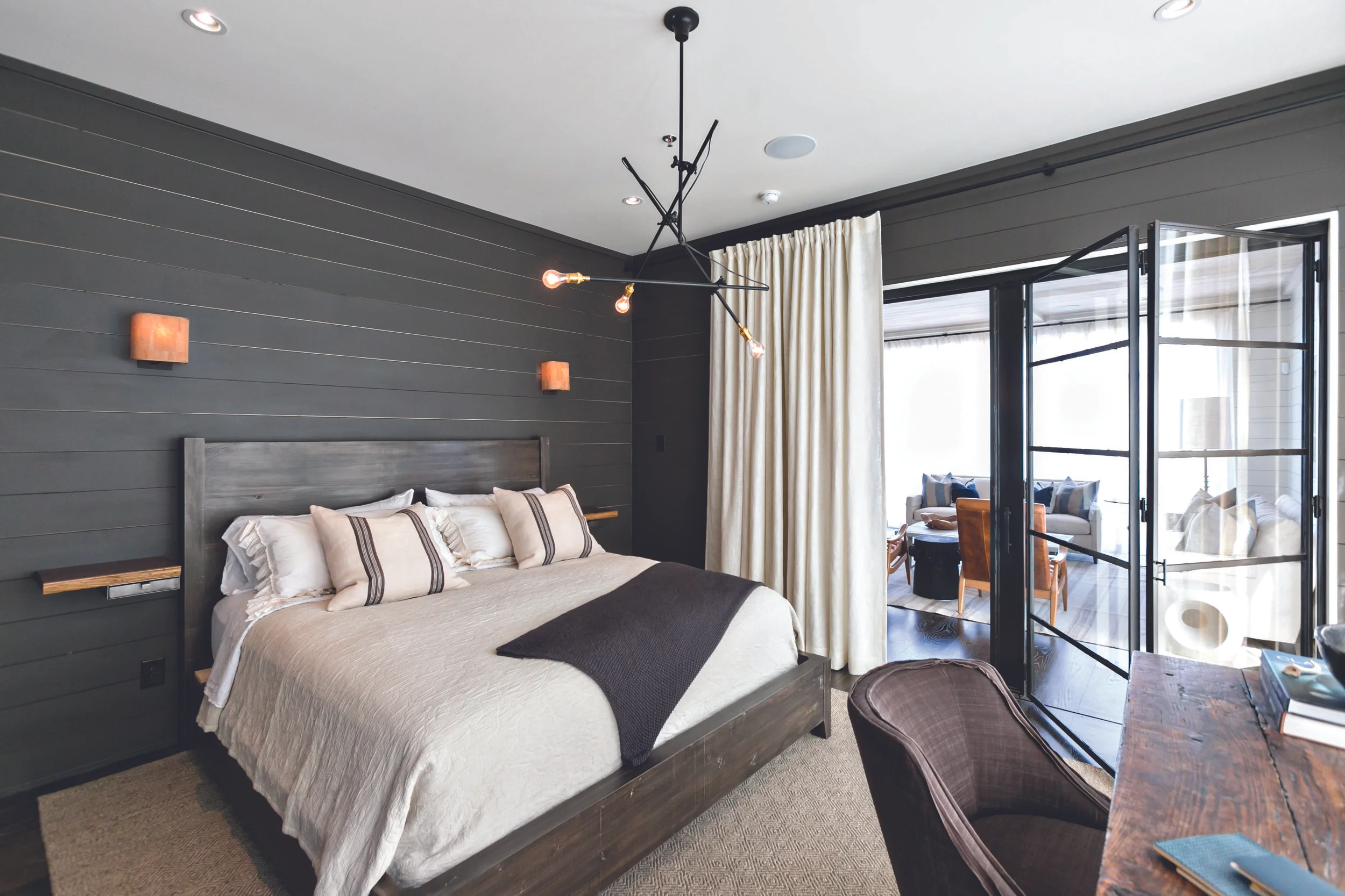 Custom features include metal and glass bi-fold doors to the master bedroom. Photo by J. Ashley Photography .