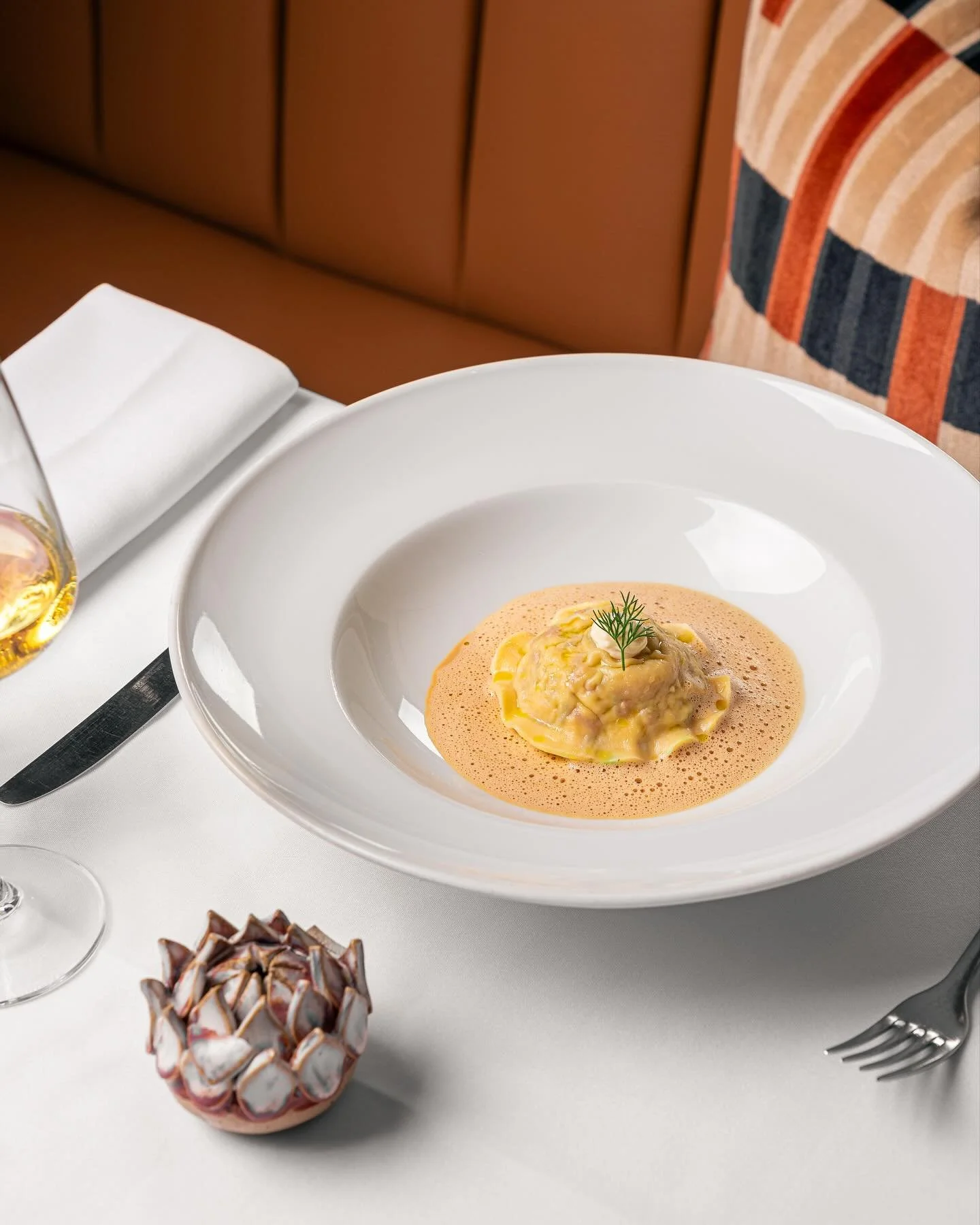 Ravioli of confit rabbit, Iberico chorizo, roasted peppers and green olive with baby artichokes and shellfish bisque