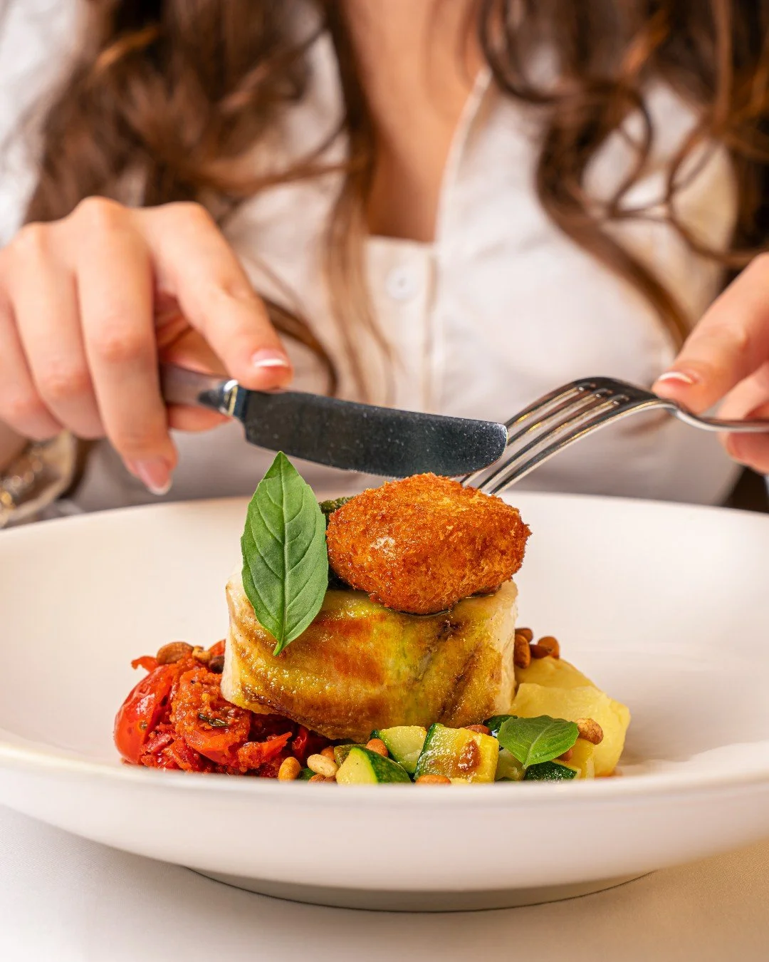 Fresh Cornish cod, gently roasted until just set, resting on olive oil mash with bright lemon and garlic courgettes. The warmth of Iberico chorizo and sweet datterini tomatoes adds richness, lifted by crispy smoked eel and pesto.

Balanced, thoughtfu