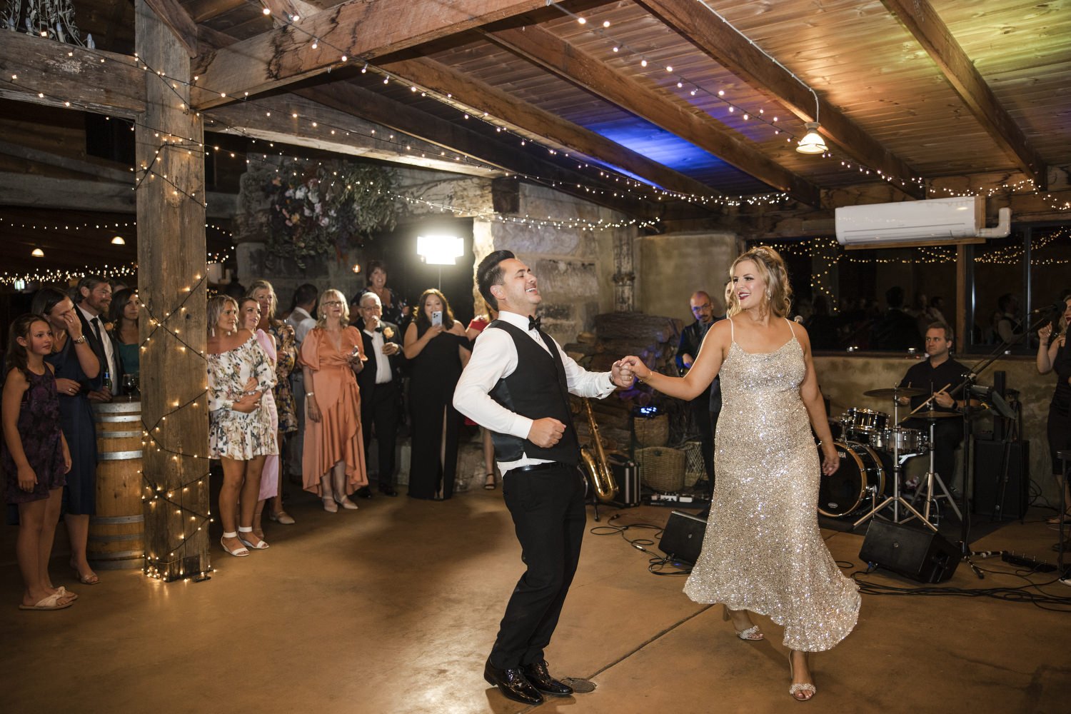 Bride and Groom dancing at Peppers Creek Barrel Room  with band in the background 