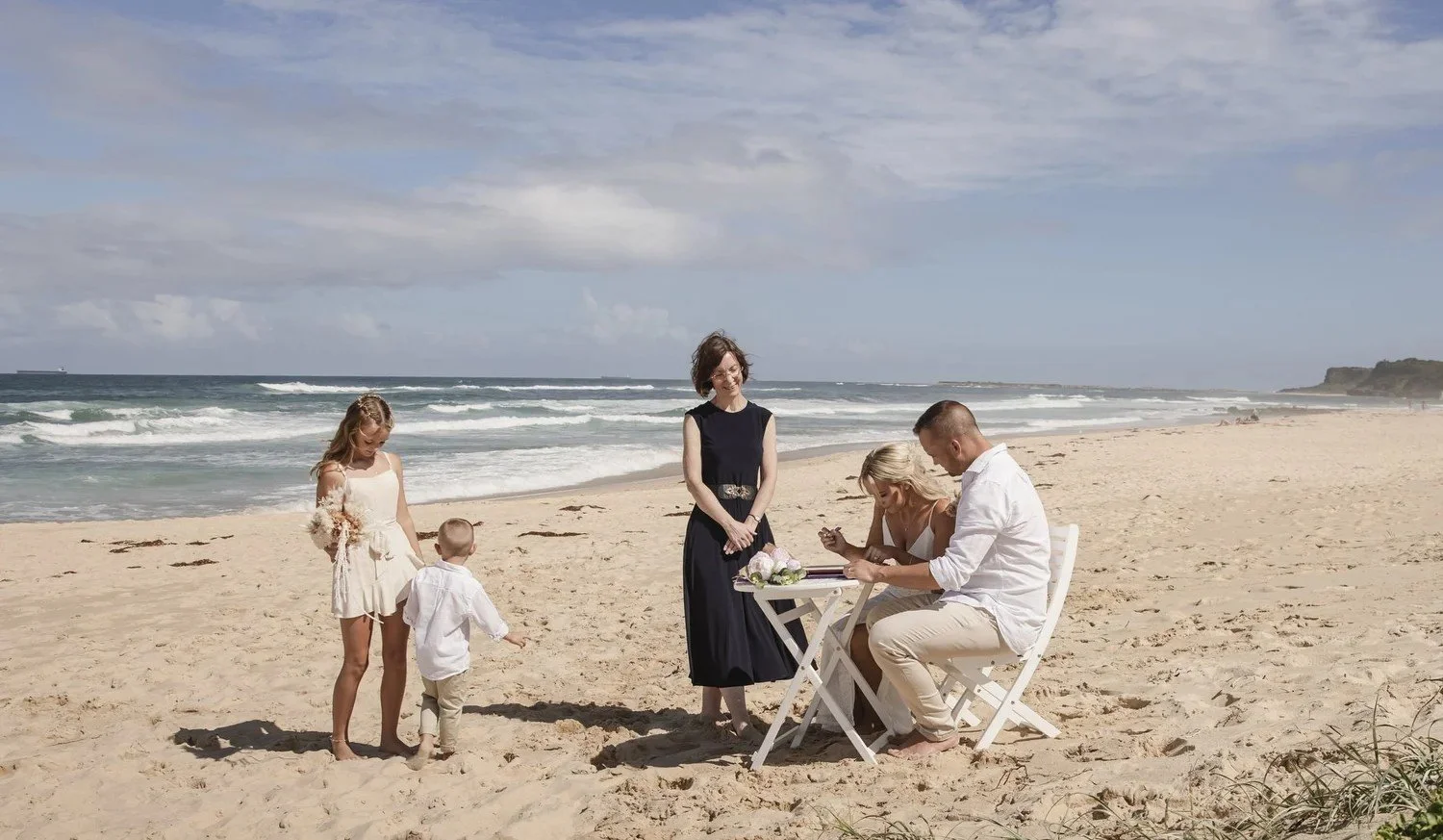 Signing the wedding certificate at a small table on the sand