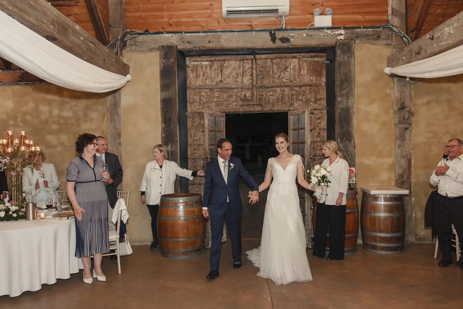 Bride and Groom walking in Peppers Creek Barrel Room  for reception 