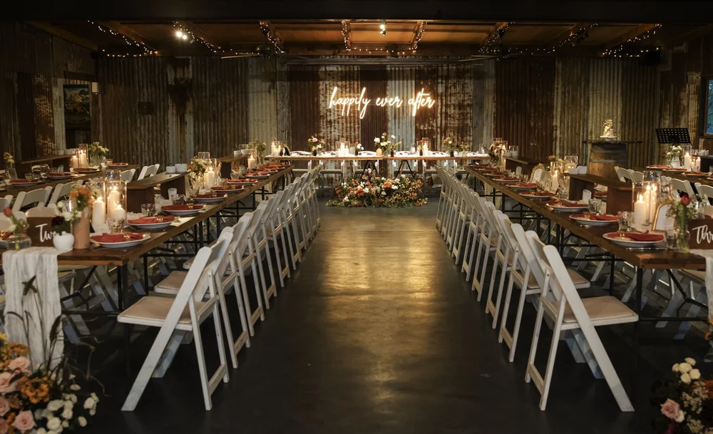 The Barn set for a reception with long timber tables and candles, Adams Peak Country Estate, Broke
