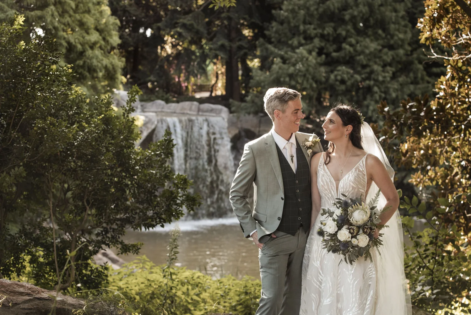 Bride and groom by the waterfall at Hunter Valley Gardens, Pokolbin