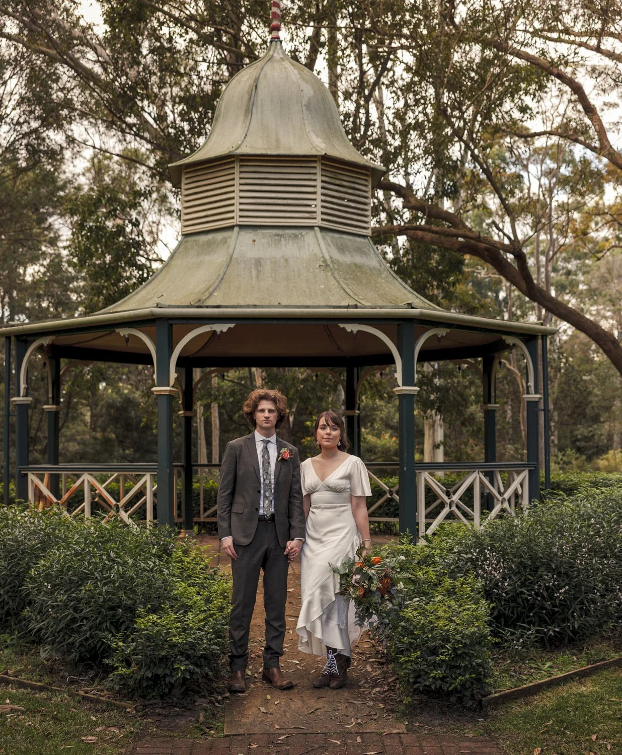 Bride and groom in front of a heritage garden rotunda in Newcastle