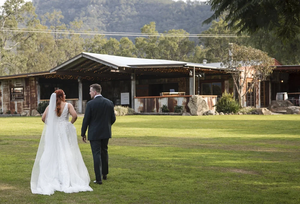 Couple walking towards the timber pavilion across the lawn, Adams Peak Country Estate, Broke