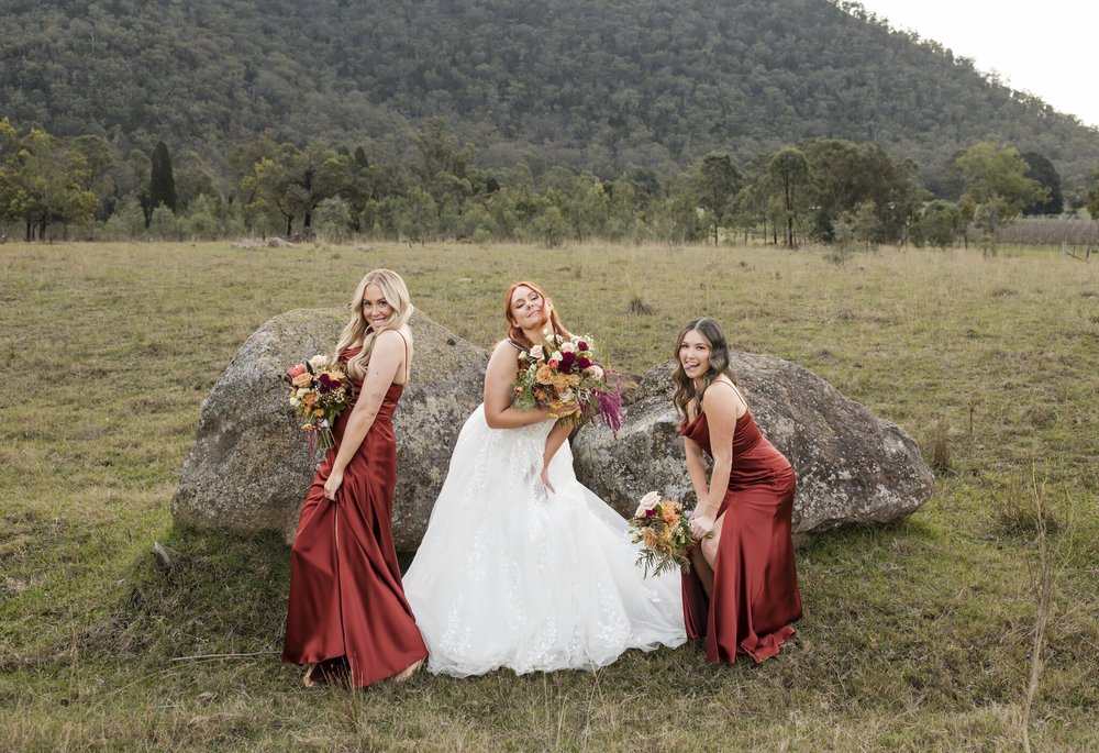 Bride and bridesmaids on the granite boulders in the long grass, Adams Peak Country Estate, Broke