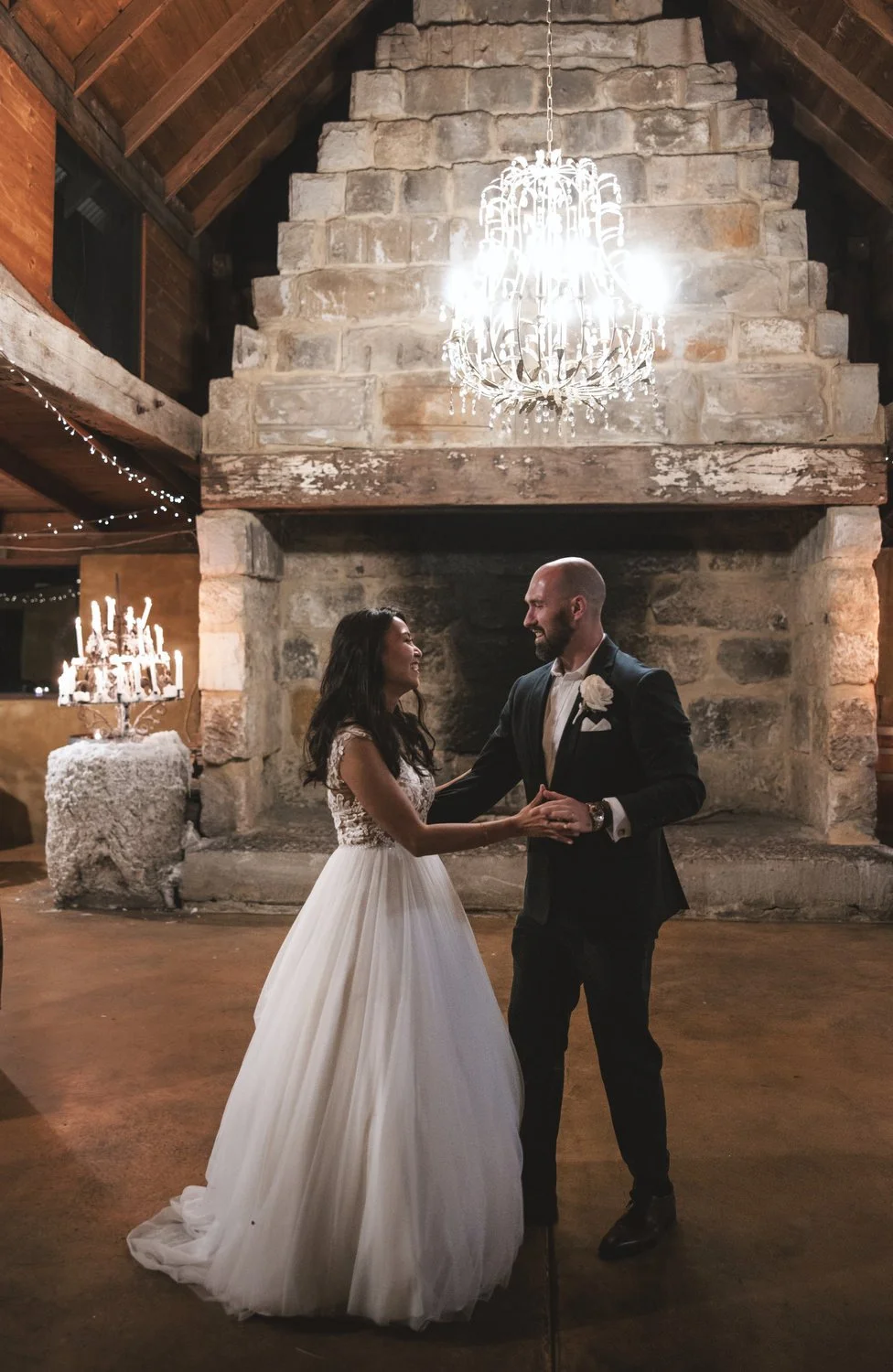 Bride and Groom dancing at Peppers Creek Barrel Room  in front of fire 