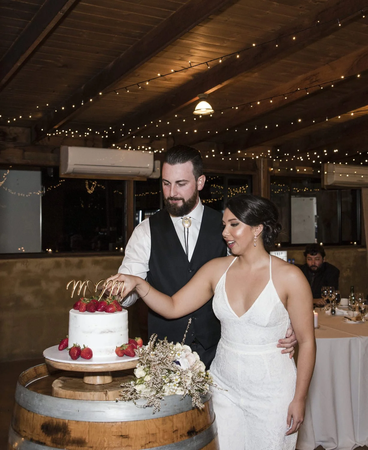 Bride and Groom cutting cake in reception at Peppers Creek Barrel Room  