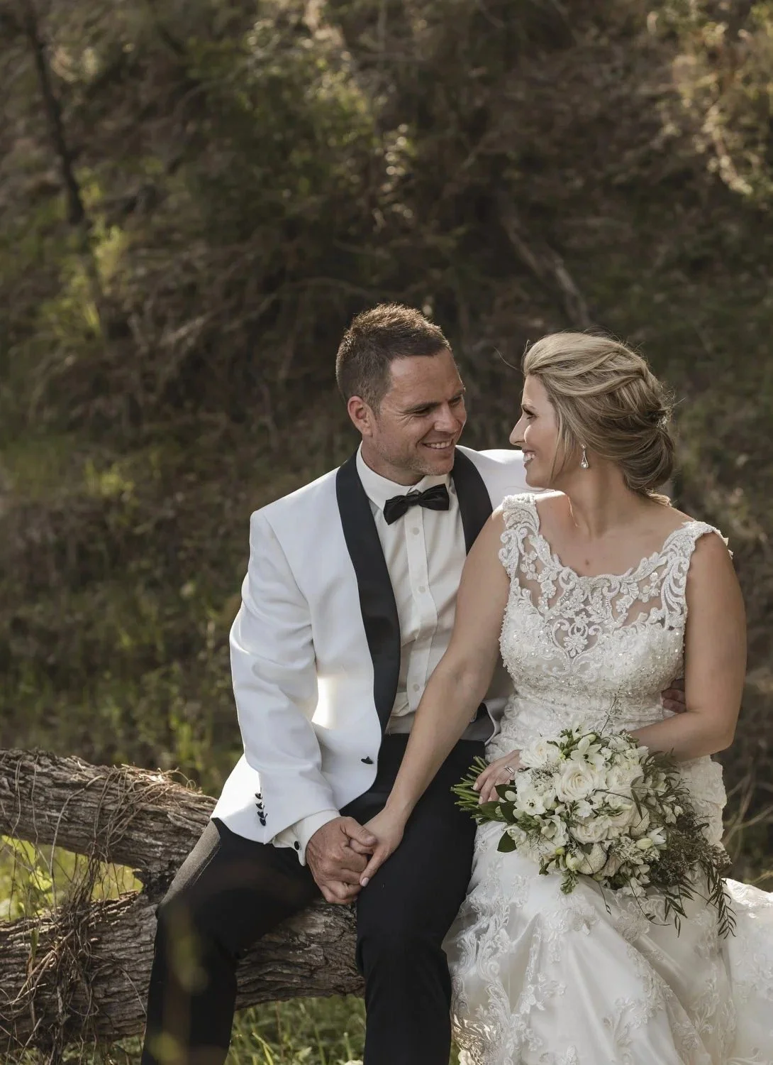 Couple laughing on a fallen log in the bushland surrounding Spicers Vineyards Estate, Pokolbin