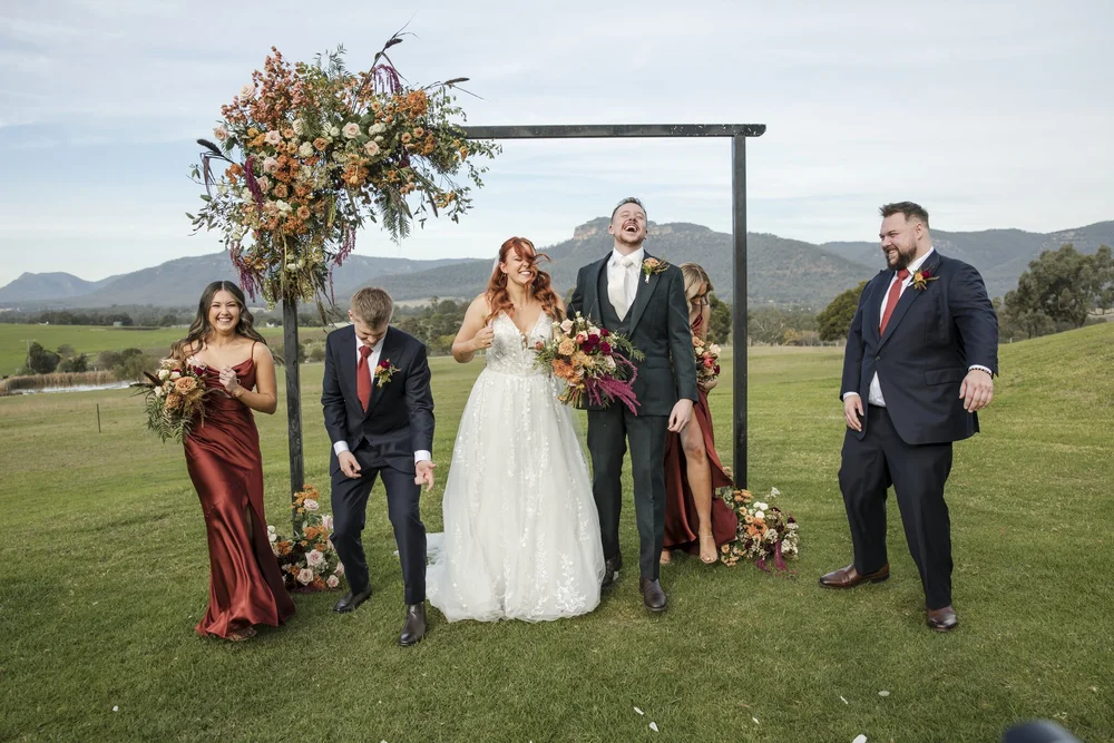 Bridal party laughing beside the ceremony arbour on the lawn, Adams Peak Country Estate, Broke