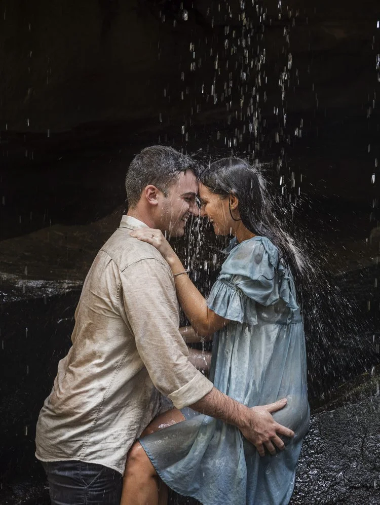 Couple embracing under a waterfall.