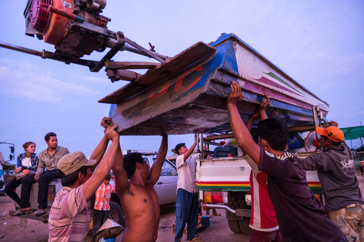 May 26, 2016 - Kampong Loung, Cambodia. People help Mai (45) and her family load their boat onto a waiting truck. The family is leaving Kampong Loung after having spent 20 years in the floating village, they will head to Vietnam where they are originally from. Low fish stocks due to climate change and over fishing on the lake has meant that the family can no longer make a living from fishing. © Nicolas Axelrod / Ruom