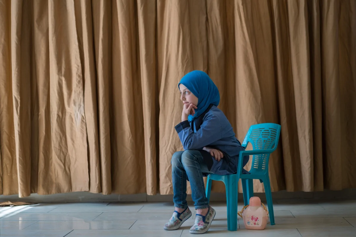 AMMAN, JORDAN - OCTOBER 1, 2015: Esma, 8, is a Syrian student at Khawla Bint Tha’laba Primary Girls School, a USAID-supported school located in an Amman suburb. She is one of around 65 Syrian students attending the USAID-supported school, which operates out of a rented building and struggles to accommodate the influx of refugees. In spite of the overcrowding, this school boasts a principal who is committed to accepting students, with one request for the parents: “Please bring a chair with you.” Overall in Jordan, around 128,000 new Syrian students are crowding already overburdened classrooms. Teachers, struggling to achieve basic levels of proficiency in their classes, have the added burden of trying to accommodate and integrate new students who have suffered unthinkable trauma and may need special counseling and care. USAID supports schools like this across Jordan by providing teacher training and by developing an early grade reading and math diagnostic tool. The agency also builds and refurbishes schools throughout the country.