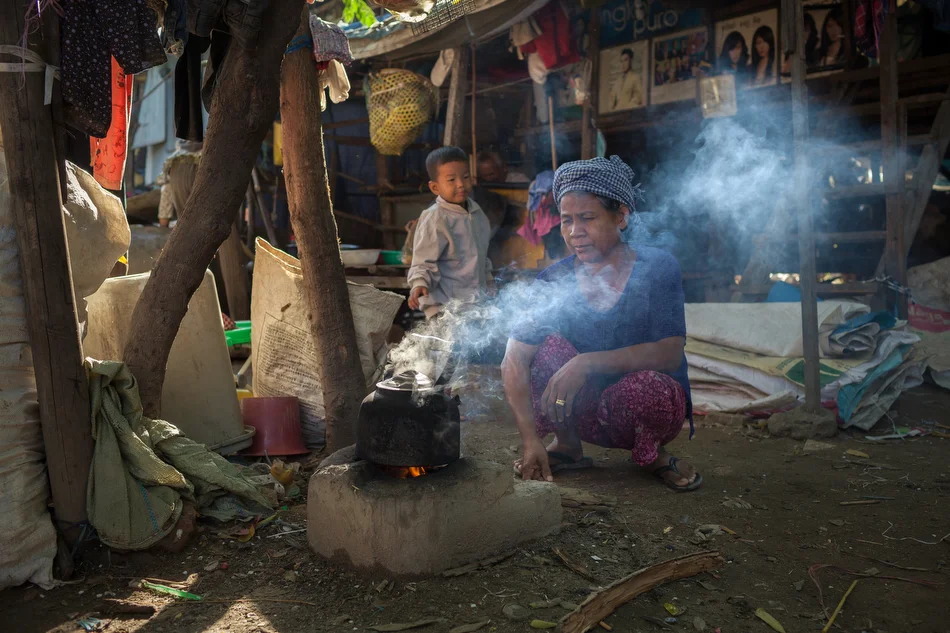19 December, 2013 - Phnom Penh. A woman boils water on a traditional wooden stove. © Thomas Cristofoletti / Ruom for SNV