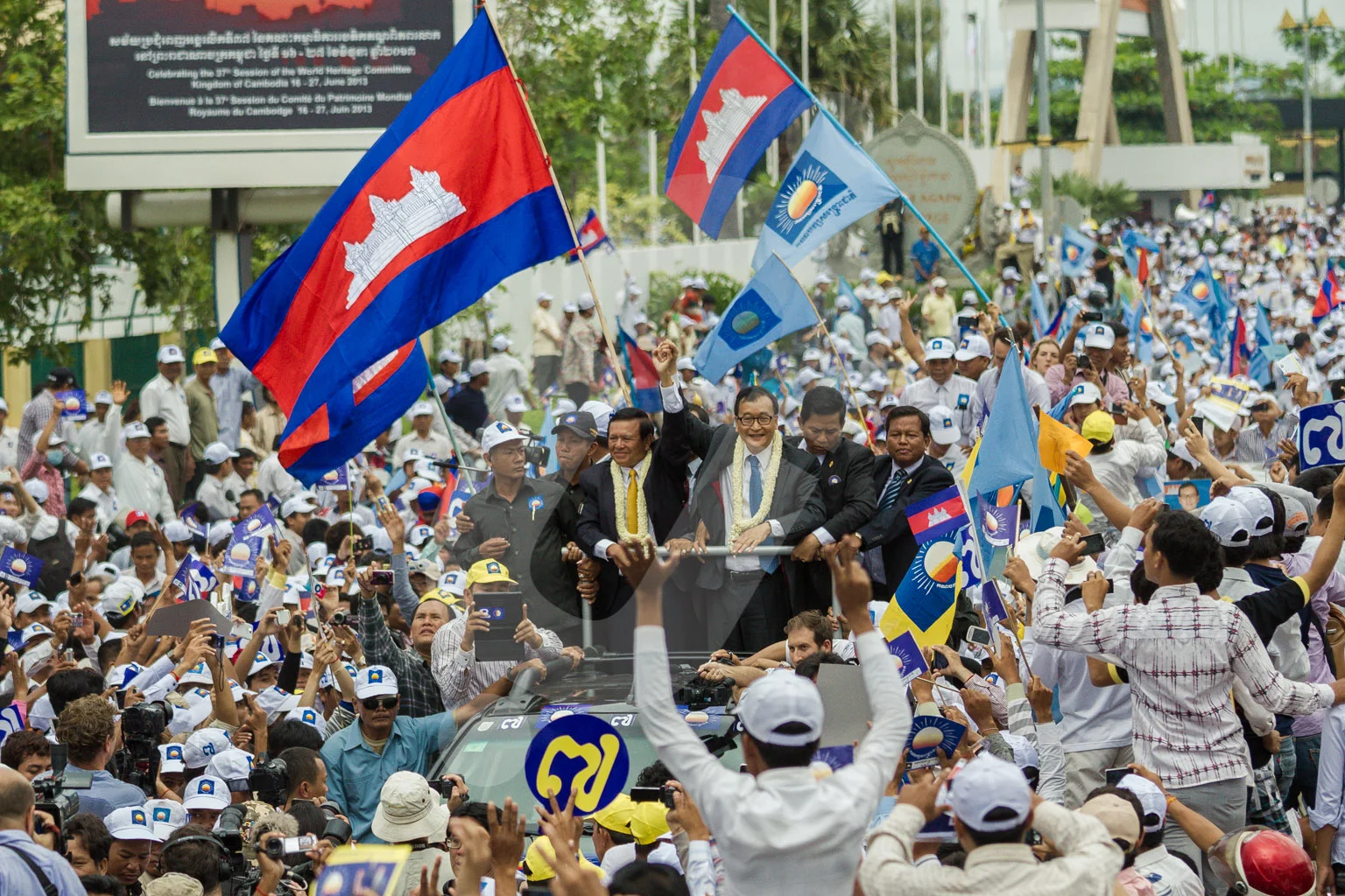 Sam Rainsy and Kem Sokha leave the airport of Phnom Penh surrounded by thousands of supporters of the CNRP party.