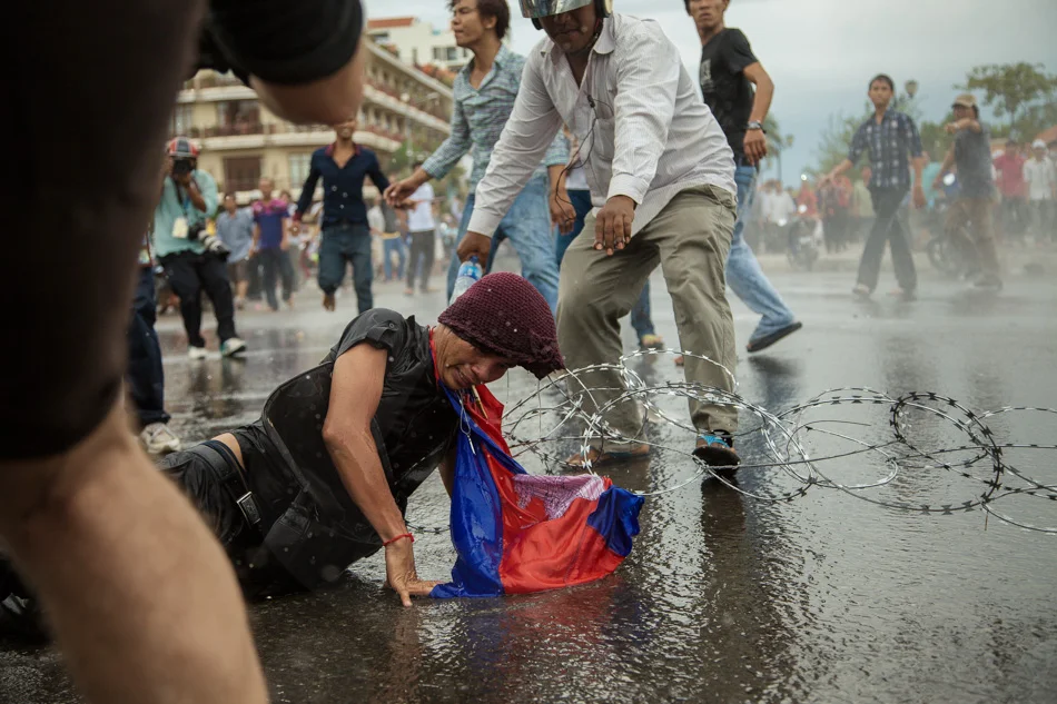 15/09/2013 - Phnom Penh. A CNRP supporter got trapped in the barb wire and injured by a water cannon. © Thomas Cristofoletti / Ruom 2013