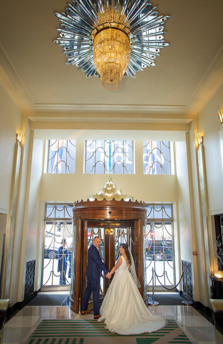 wedding-photograph-claridges-lobby-entrance-chandelier-couple.jpg
